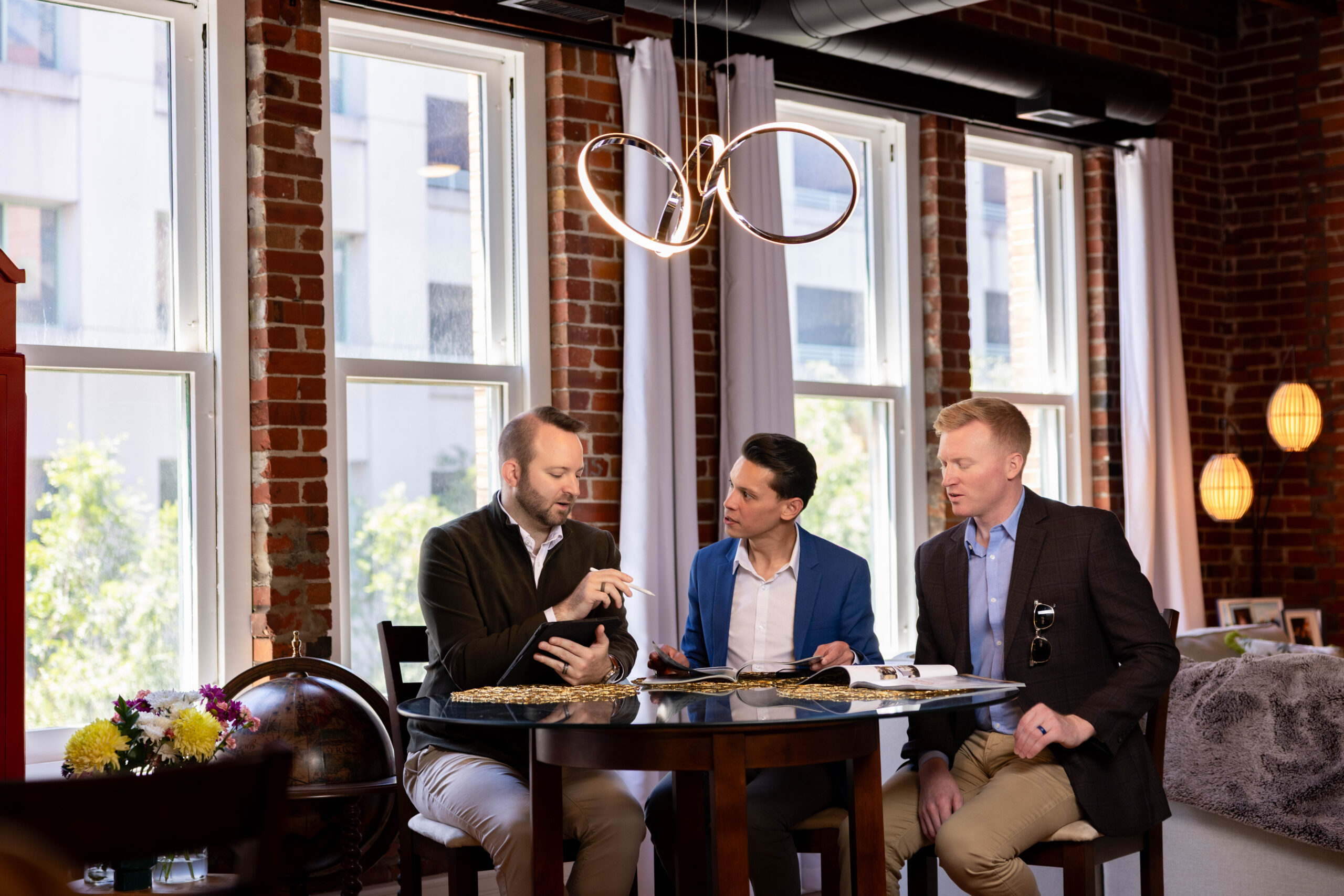 Travel Consultation with couple and their advisor from CARTE ATLAS at a table in a brick loft.