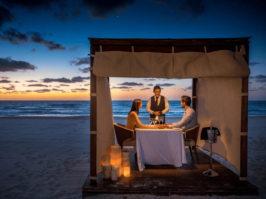 Dining in a cabana on the beach at sunset. 