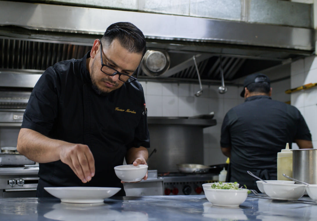 Chef preparing food in kitchen.